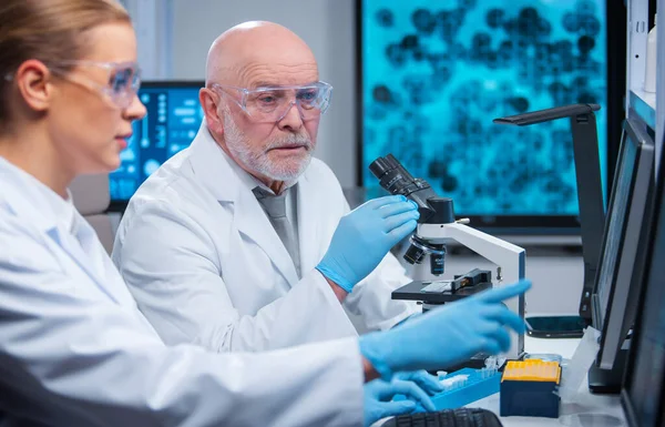 Professor e médico trabalham em um laboratório científico moderno usando equipamentos e computadorestecnologias. Grupo de cientistas fazer pesquisa e desenvolver novas vacinas. Conceito de ciência e saúde. — Fotografia de Stock