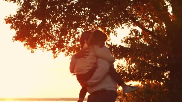 Sevgi dolu aile gün batımında kırsalda dolaşır. Baba kızıyla oynuyor. Aşk kavramı, aile bakımı ve çocuklar.. — Stok video