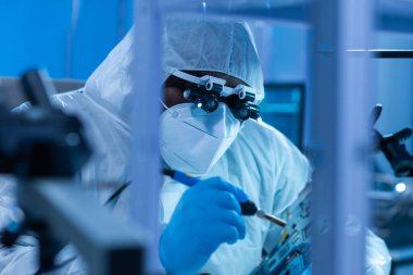 Afrikalı-Amerikalı bilim adamı, mikro elektronik ve işlemcilerin araştırılması ve geliştirilmesi için modern bir bilim laboratuvarında çalışıyor. Üretim işçisi bilgisayar teknolojisi ve ekipmanı kullanıyor.