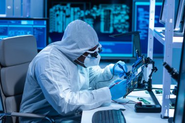 Afrikalı-Amerikalı bilim adamı, mikro elektronik ve işlemcilerin araştırılması ve geliştirilmesi için modern bir bilim laboratuvarında çalışıyor. Üretim işçisi bilgisayar teknolojisi ve ekipmanı kullanıyor.