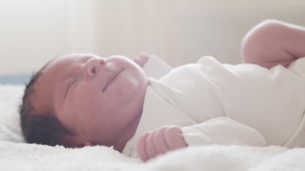 Närbild porträtt av en ung baby som nyligen har fötts. Nyfödd spädbarnspojke hemma. Fönsterljus. — Stockvideo