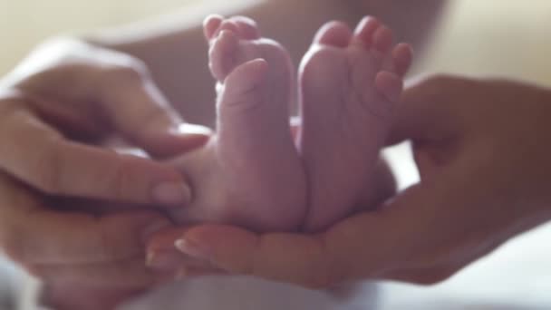 Крупным планом ноги кормящего ребенка, который недавно родился. Новорожденный мальчик дома. Огни окон. — стоковое видео