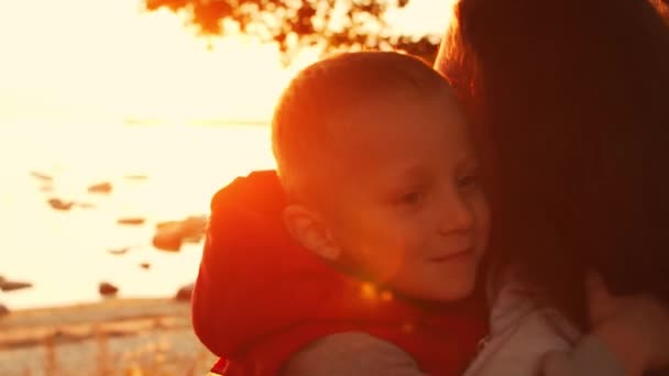 Liebevolle Familienspaziergänge in der Natur während des Sonnenuntergangs. Mutter spielt mit ihrem Sohn. Das Konzept der Liebe, der elterlichen Sorge und der Kinder. — Stockvideo