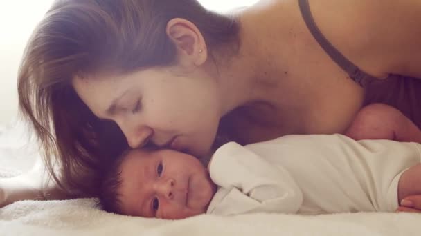 Niño recién nacido y su madre en casa. Retrato de cerca del bebé que ha nacido recientemente. Luz de ventana. — Vídeos de Stock