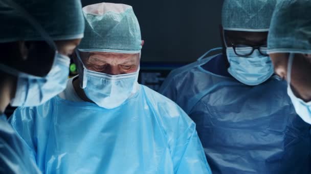 Wielorasowy zespół profesjonalnych lekarzy wykonuje operację chirurgiczną w nowoczesnym szpitalu. Lekarze pracują nad ratowaniem pacjenta. Medycyna, zdrowie, kardiologia i transplantacja. — Wideo stockowe