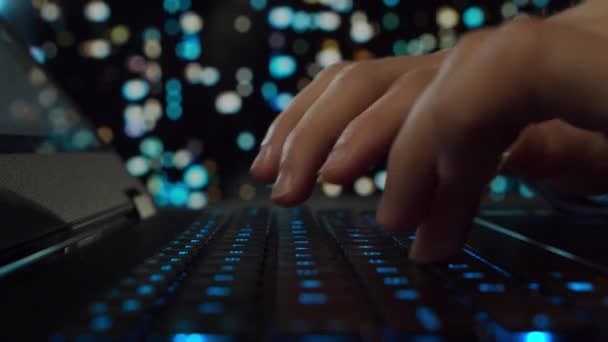 Händerna på en ung man som arbetar vid en dator. Programmeraren skriver på en speldator. Nattstad i bakgrunden. Affärs-, kodnings- och utbyteskoncept. — Stockvideo