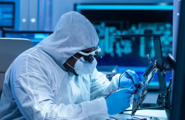 Afrikalı-Amerikalı bilim adamı, mikro elektronik ve işlemcilerin araştırılması ve geliştirilmesi için modern bir bilim laboratuvarında çalışıyor. Üretim işçisi bilgisayar teknolojisi ve ekipmanı kullanıyor.