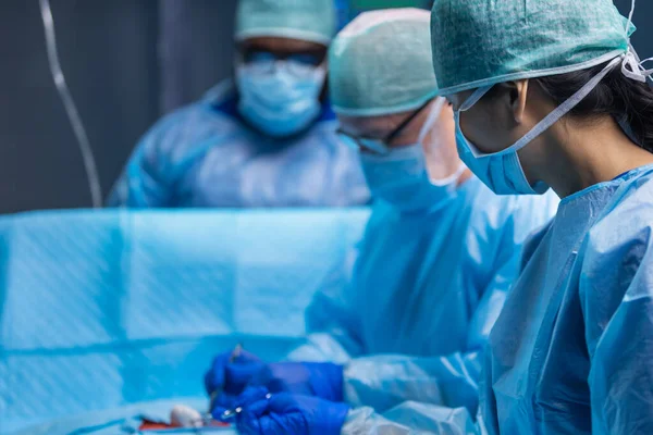 Equipe multirracial de cirurgiões médicos profissionais realiza a operação cirúrgica em um hospital moderno. Os médicos estão a trabalhar para salvar o paciente. Medicina, saúde, cardiologia e transplante. — Fotografia de Stock