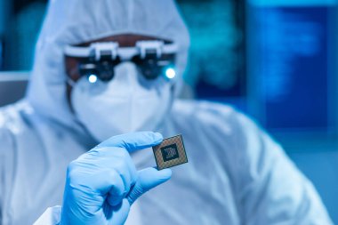 Afrikalı-Amerikalı bilim adamı, mikro elektronik ve işlemcilerin araştırılması ve geliştirilmesi için modern bir bilim laboratuvarında çalışıyor. Üretim işçisi bilgisayar teknolojisi ve ekipmanı kullanıyor.