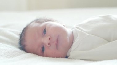 Yakın zamanda doğan bir bebeğin yakın plan portresi. Yeni doğmuş erkek bebek evde. Pencere ışığı.