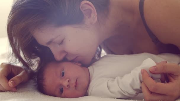 Niño recién nacido y su madre en casa. Retrato de cerca del bebé que ha nacido recientemente. Luz de ventana. — Vídeo de stock