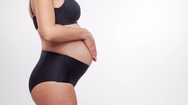 Młoda, szczęśliwa i zdrowa kobieta w ciąży na białym tle. Teledysk. Spodziewanie się dziecka, ciąża i macierzyństwo. — Wideo stockowe
