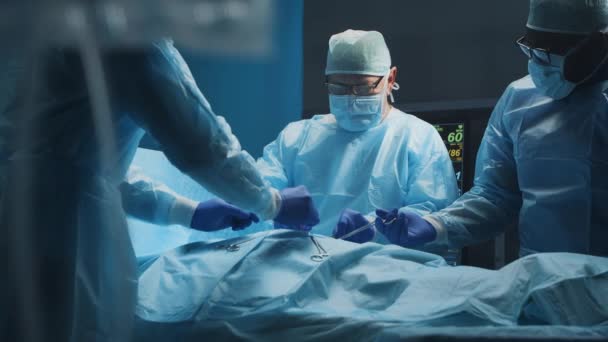 Ein multiethnisches Team professioneller Chirurgen führt den chirurgischen Eingriff in einem modernen Krankenhaus durch. Ärzte arbeiten daran, den Patienten zu retten. Medizin, Gesundheit, Kardiologie und Transplantation. — Stockvideo