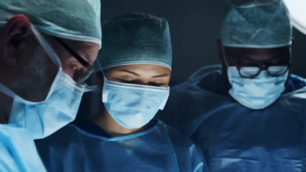 Il team multirazziale di medici chirurghi professionisti esegue l'operazione chirurgica in un moderno ospedale. I medici stanno lavorando per salvare il paziente. Medicina, salute, cardiologia e trapianto. — Video Stock