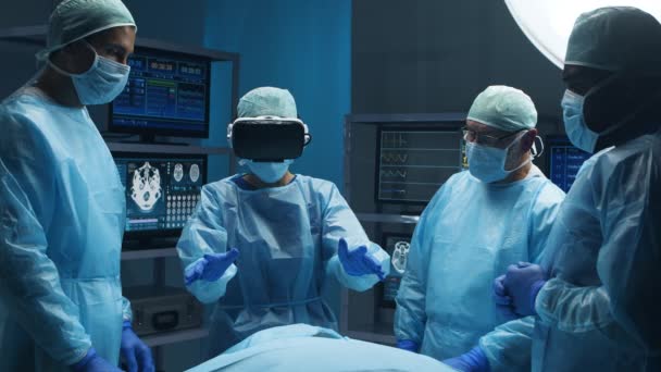 El equipo multirracial de cirujanos médicos profesionales realiza la operación quirúrgica en un hospital moderno utilizando la tecnología de realidad virtual. Concepto de medicina, salud y neurocirugía. — Vídeos de Stock