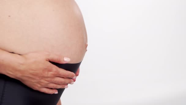 Ung, glad och frisk gravid kvinna på vit bakgrund. Studio-video. Förväntad baby, graviditet och moderskap. — Stockvideo