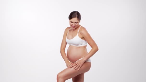 Giovane, felice e sana donna incinta su sfondo bianco. Video dello studio. Aspettativa del bambino, gravidanza e concetto di maternità. — Video Stock