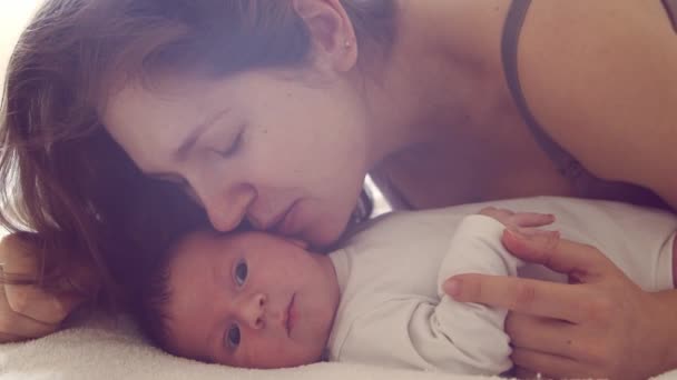 Новорожденный мальчик и его мать дома. Крупный план портрета новорожденного. Огни окон. — стоковое видео