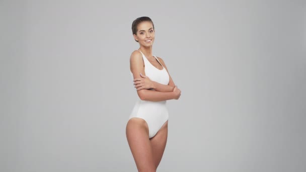 Giovane, bella, in forma e naturale donna bionda in costume da bagno bianco. Epilazione, cura della pelle, rimozione della cellulite e concetti di perdita di peso. — Video Stock