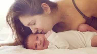 Yeni doğmuş erkek bebek ve annesi evde. Yakın zamanda doğan bir bebeğin yakın plan portresi. Pencere ışığı.