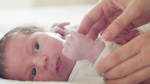 Közelkép egy kisbabáról, aki nemrég született. Újszülött kisfiú otthon. Ablakvilágítás. — Stock videók