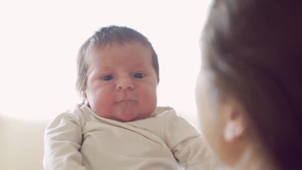 Pasgeboren baby jongen en zijn moeder thuis. Close-up portret van het pasgeboren kind. Raamlicht. — Stockvideo