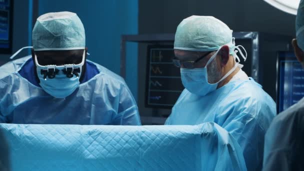 Ein multiethnisches Team professioneller Chirurgen führt den chirurgischen Eingriff in einem modernen Krankenhaus durch. Ärzte arbeiten daran, den Patienten zu retten. Medizin, Gesundheit und Neurochirurgie. — Stockvideo