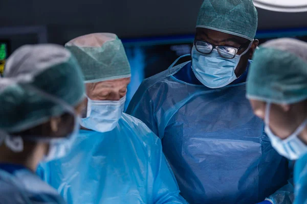 Professzionális orvosi sebészek multiracionális csapata végzi a műtétet egy modern kórházban. Az orvosok azon dolgoznak, hogy megmentsék a beteget. Gyógyászat, egészségügy, kardiológia és transzplantáció. — Stock Fotó
