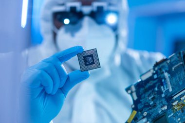 Afrikalı-Amerikalı bilim adamı, mikro elektronik ve işlemcilerin araştırılması ve geliştirilmesi için modern bir bilim laboratuvarında çalışıyor. Üretim işçisi bilgisayar teknolojisi ve ekipmanı kullanıyor.