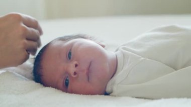 Yakın zamanda doğan bir bebeğin yakın plan portresi. Yeni doğmuş erkek bebek evde. Pencere ışığı.