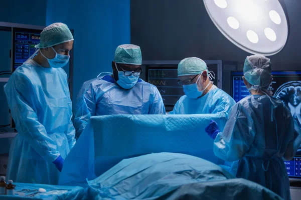 Une équipe multiraciale de chirurgiens médicaux professionnels effectue l'opération chirurgicale dans un hôpital moderne. Les médecins travaillent pour sauver le patient. Médecine, santé et neurochirurgie. — Photo