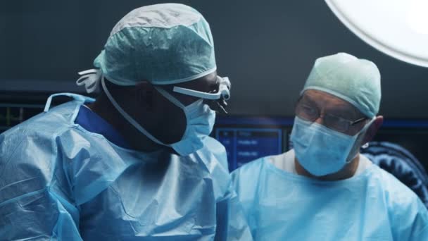 Multiraciale team van professionele chirurgen voert de chirurgische ingreep in een modern ziekenhuis. Artsen proberen de patiënt te redden. Geneeskunde, gezondheid en neurochirurgie. — Stockvideo