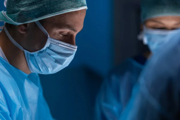 El equipo multirracial de cirujanos médicos profesionales realiza la operación quirúrgica en un hospital moderno. Los médicos están trabajando para salvar al paciente. Medicina, salud, cardiología y trasplante. —  Fotos de Stock