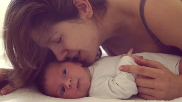Nyfödd pojke och hans mamma hemma. Närbild porträtt av barnet som nyligen har fötts. Fönsterljus. — Stockvideo