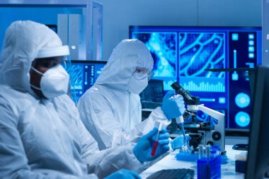 Afrikalı-Amerikalı bilim adamı laboratuvar ekipmanları, mikroskop ve bilgisayar teknolojisi kullanarak bir laboratuarda çalışıyor. Yeni ilaçların ve aşıların icadı. Bilim ve Sağlık kavramı.