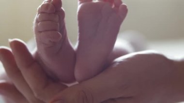 Yakın zamanda doğan emziren bir bebeğin yakın çekimi. Yeni doğmuş erkek bebek evde. Pencere ışığı.