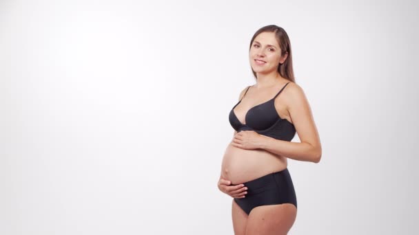 Giovane, felice e sana donna incinta su sfondo bianco. Video dello studio. Aspettativa del bambino, gravidanza e concetto di maternità. — Video Stock