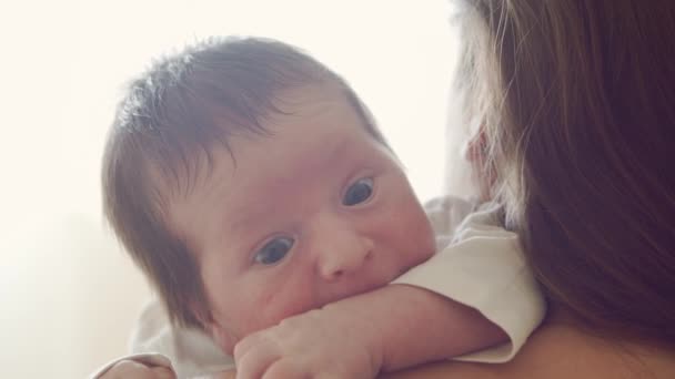 갓 태어난 사내 아이와 집에 있는 그 의 어머니. 최근에 태어난 아기의 근접 사진입니다. 창유리. — 비디오