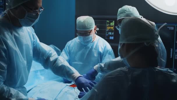Multiracial team of professional medical surgeons performs the surgical operation in a modern hospital. Doctors are working to save the patient. Medicine, health, cardiology and transplantation. — Stock Video