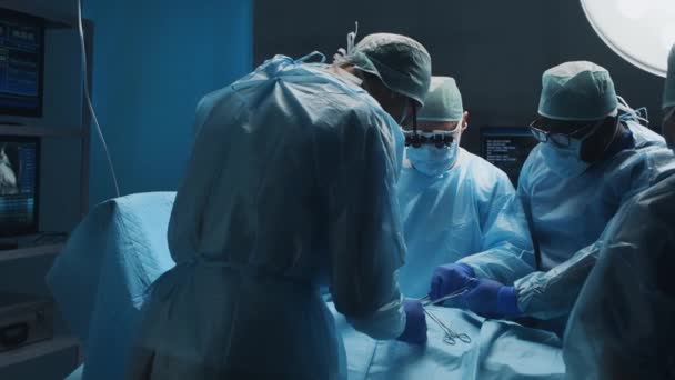 Ein multiethnisches Team professioneller Chirurgen führt den chirurgischen Eingriff in einem modernen Krankenhaus durch. Ärzte arbeiten daran, den Patienten zu retten. Medizin, Gesundheit, Kardiologie und Transplantation. — Stockvideo