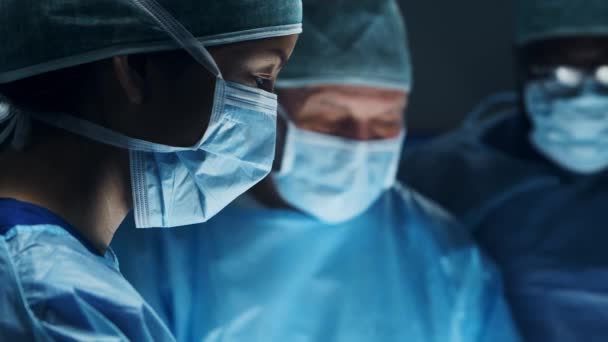 プロの外科医の多人種チームは、現代の病院で外科手術を行います。医者は患者を救うために働いている。医学、健康、心臓学、移植. — ストック動画