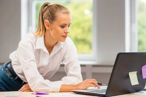 Lieu de travail d'une travailleuse indépendante ou d'une étudiante au bureau à domicile. Jeune femme travaille à l'aide d'un ordinateur et d'autres appareils. Concept d'emploi à distance. — Photo