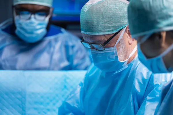 プロの外科医の多人種チームは、現代の病院で外科手術を行います。医者は患者を救うために働いている。医学、健康、心臓学、移植. — ストック写真