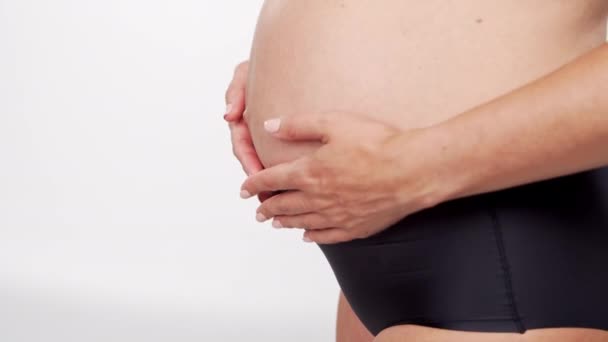 Junge, glückliche und gesunde Schwangere auf weißem Hintergrund. Studio video. Babyerwartung, Schwangerschaft und Mutterschaftskonzept. — Stockvideo