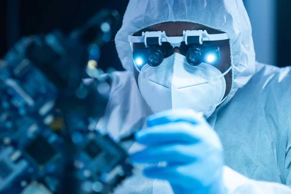 African-American scientist works in a modern scientific laboratory for the research and development of microelectronics and processors. Manufacturing worker uses computer technology and equipment. — Stock Photo, Image