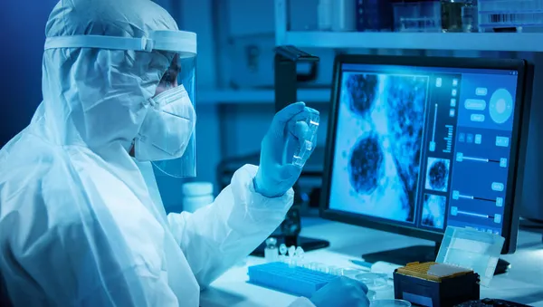 A tudós egy modern tudományos laborban dolgozik laboratóriumi berendezésekkel, mikroszkóppal és számítógépes technológiával. Új vakcinák feltalálása. A tudomány és az egészség fogalma. — Stock Fotó