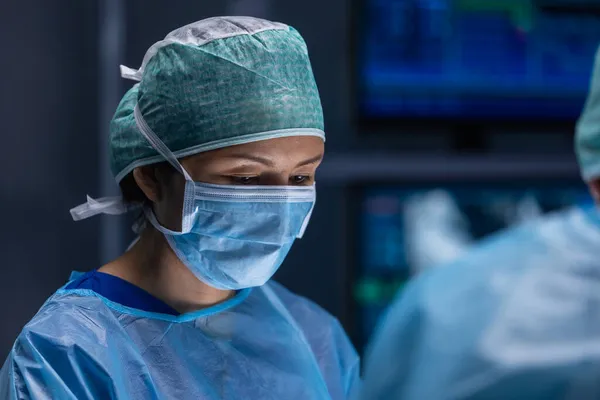 Profesyonel tıp cerrahlarından oluşan çok ırklı bir ekip modern bir hastanede cerrahi operasyon gerçekleştiriyor. Doktorlar hastayı kurtarmaya çalışıyor. İlaç, sağlık, kardiyoloji ve organ nakli. — Stok fotoğraf
