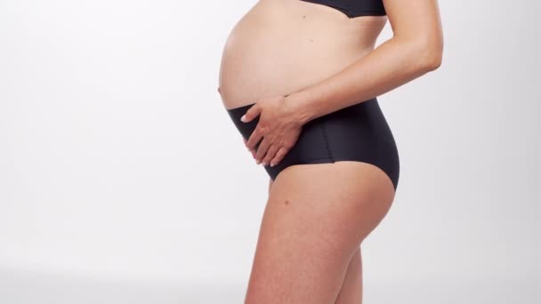 Νέα, ευτυχισμένη και υγιής έγκυος γυναίκα σε λευκό φόντο. Βίντεο στούντιο. Μωρό προσδοκία, την εγκυμοσύνη και την έννοια της μητρότητας. — Αρχείο Βίντεο