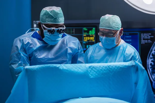 Une équipe multiraciale de chirurgiens médicaux professionnels effectue l'opération chirurgicale dans un hôpital moderne. Les médecins travaillent pour sauver le patient. Médecine, santé et neurochirurgie. — Photo