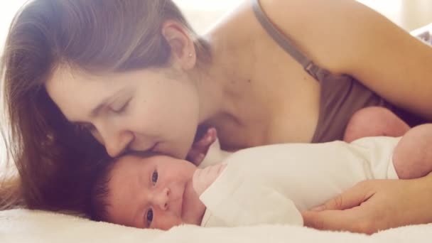 Newborn baby boy and his mother at home. Close-up portrait of the infant who has recently been born. Window light. — Stock Video